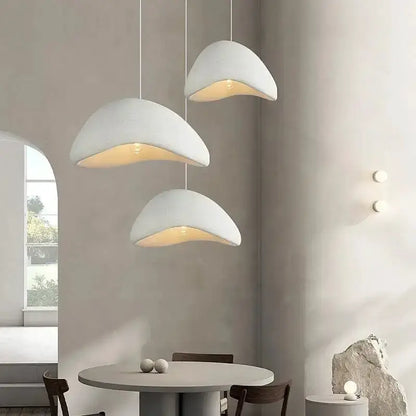 Three modern gray dome pendant lights by Decorbites with warm yellow interior over dining table on Tampa Home & Garden Store