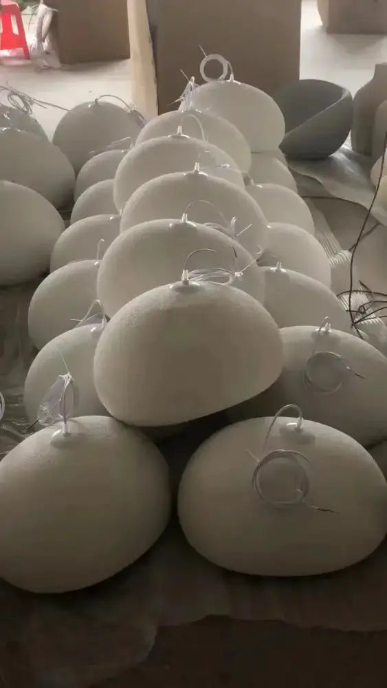 White dome pendant lights set for dining room, multiple spherical fixtures with cords on Tampa Home & Garden Store
