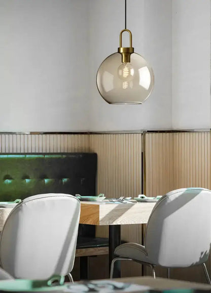 Modern smoked-glass brass pendant light by Decorbites over dining table on Tampa Home & Garden Store