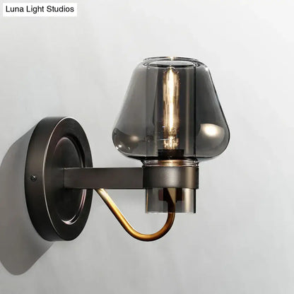 Black brass mushroom sconce with smoky glass shade and exposed filament bulb on Tampa Home & Garden Store