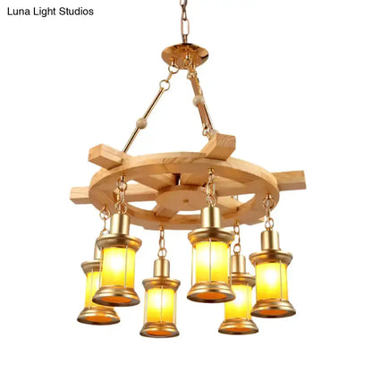 Rustic industrial wood spool pendant chandelier with six amber lanterns and brass hardware on Tampa Home & Garden Store