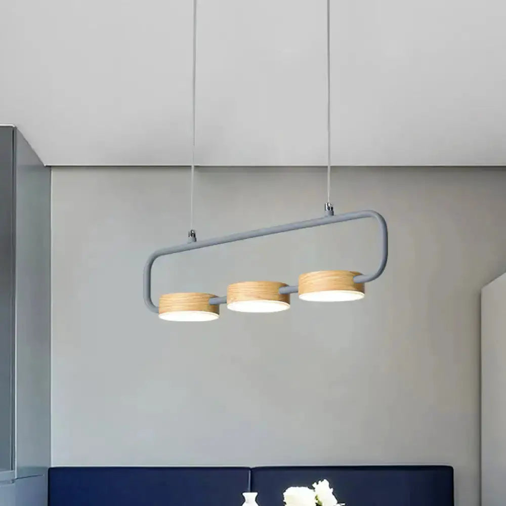 Modern mint-green three-light pendant with wood accents over kitchen island on Tampa Home & Garden Store