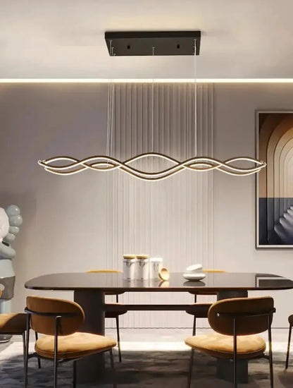 Chandelier elongated wave LED pendant light with metallic finish over dining table on Tampa Home & Garden Store