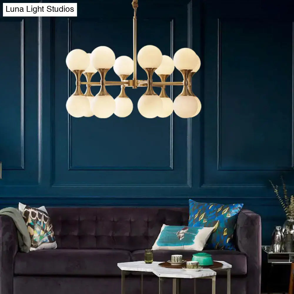 Brass Globe Chandelier with frosted glass globes on brass arms over a navy wall on Tampa Home & Garden Store