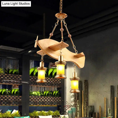 Vintage gold woven pendant light with orange glass lanterns suspended from a wooden canopy on Tampa Home & Garden Store