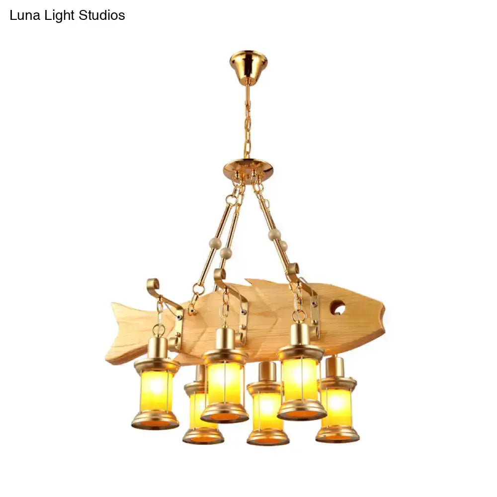 Vintage gold woven pendant light with orange glass lanterns over a fish-shaped wooden back on Tampa Home & Garden Store