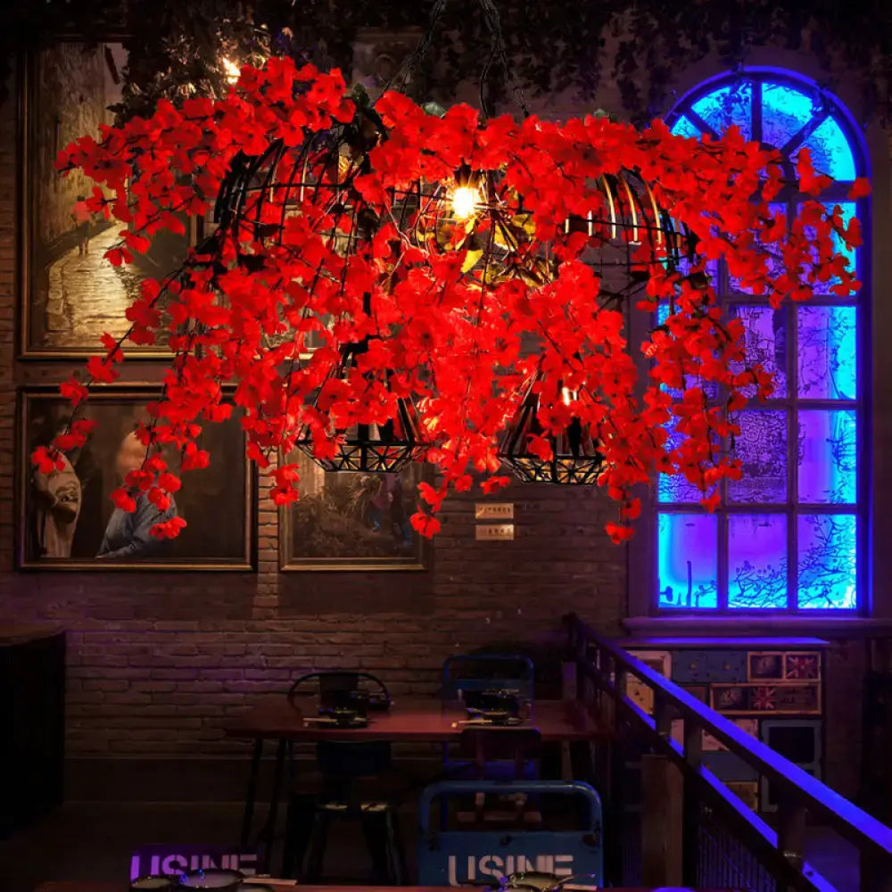 Red Diamond Cage Pendant light wrapped in cascading red flowers around black geometric cages in an industrial dining space on Tampa Home & Garden Store