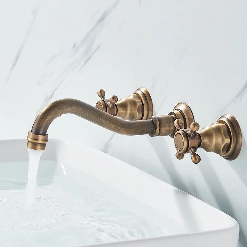 Antique brass wall faucet with curved spout and dual cross handles for bathroom sinks on Tampa Home & Garden Store