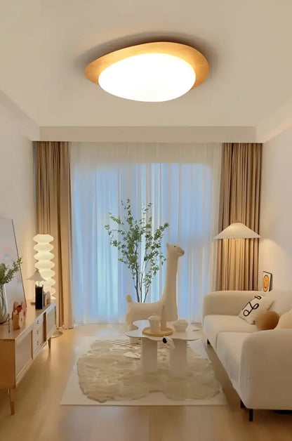 Walnut oval acrylic ceiling light flush mount with warm white glow in modern living room on Tampa Home & Garden Store