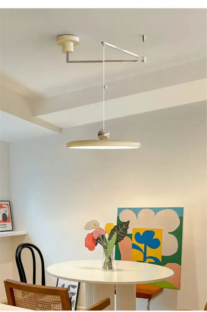 Decorbites red rotatable LED pendant light with adjustable arm over a white dining table on Tampa Home & Garden Store