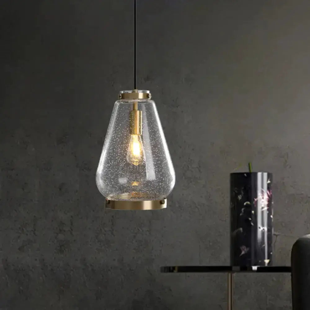 Modern seeded glass pendant light with brass rim and exposed Edison bulb on Tampa Home & Garden Store