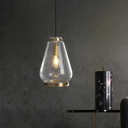 Modern seeded glass pendant light with brass rim and exposed Edison bulb on Tampa Home & Garden Store