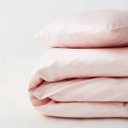 Pink satin duvet cover set folded neatly with soft pastel folds on Tampa Home & Garden Store