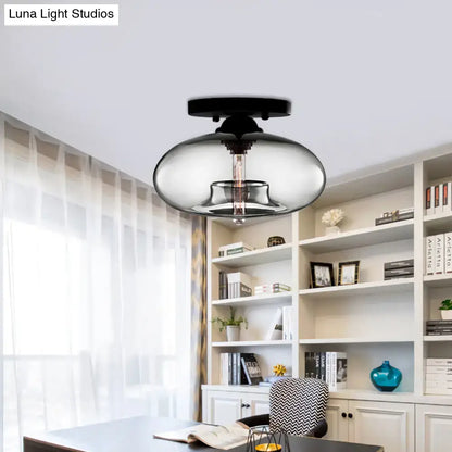 Glass oval flush mount ceiling light with clear glass shade and black canopy in a home office on Tampa Home & Garden Store