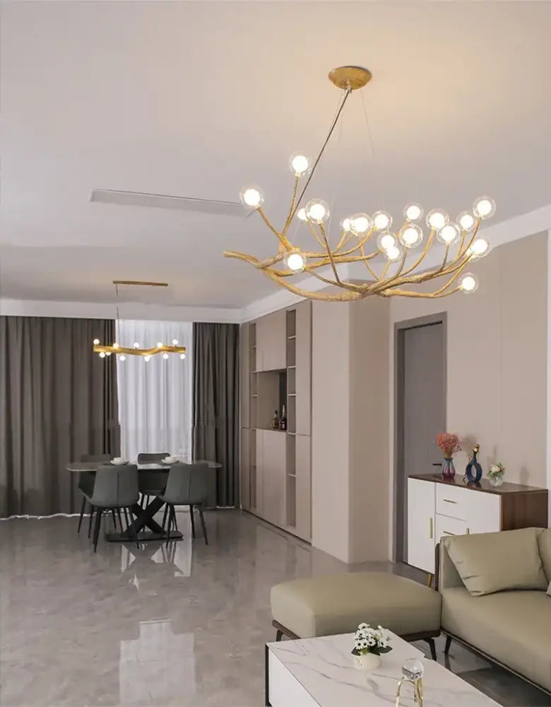 Golden iron tree-branch chandelier by Decorbites with bubble bulbs over dining area on Tampa Home & Garden Store
