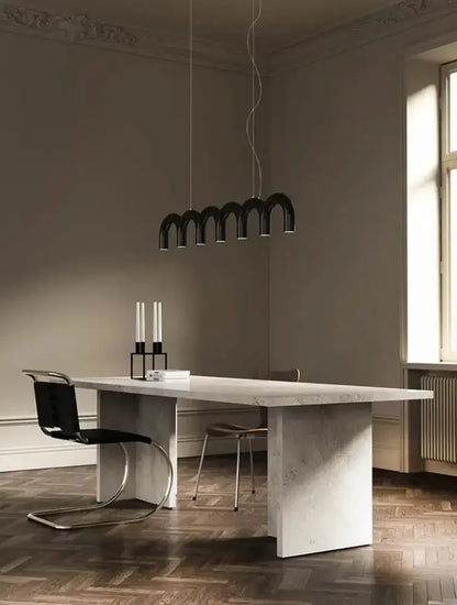 Modern black u-shaped chandelier by Decorbites over a marble dining table in a sleek dining room on Tampa Home & Garden Store