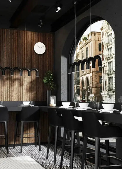 Chandelier Decorbites modern black U-shaped arches over a bar in a sleek dining space on Tampa Home & Garden Store
