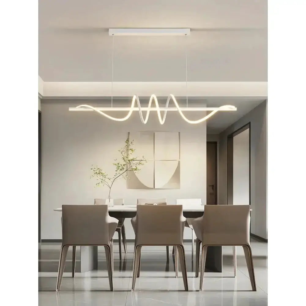 Decorbites sleek wavy pendant light with brushed metallic finish over a dining table on Tampa Home & Garden Store