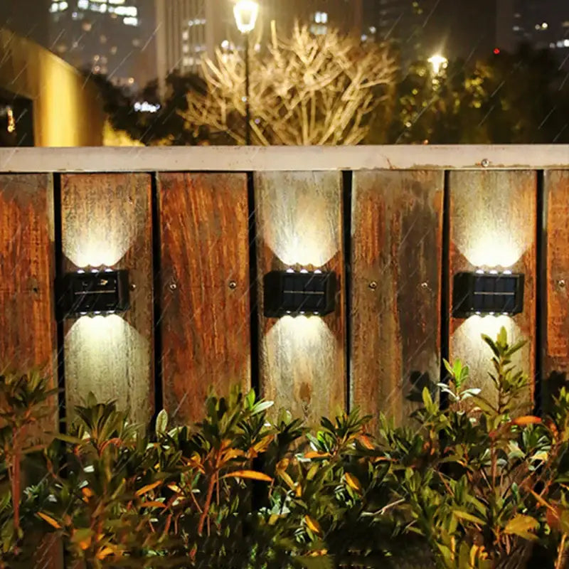 Black solar wall light by Decorbites, outdoor lighting on a wooden fence with three units on Tampa Home & Garden Store