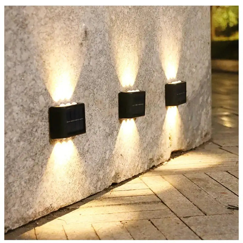 Decorbites black solar wall lights (3-pack) outdoor lighting mounted on a stone wall on Tampa Home & Garden Store