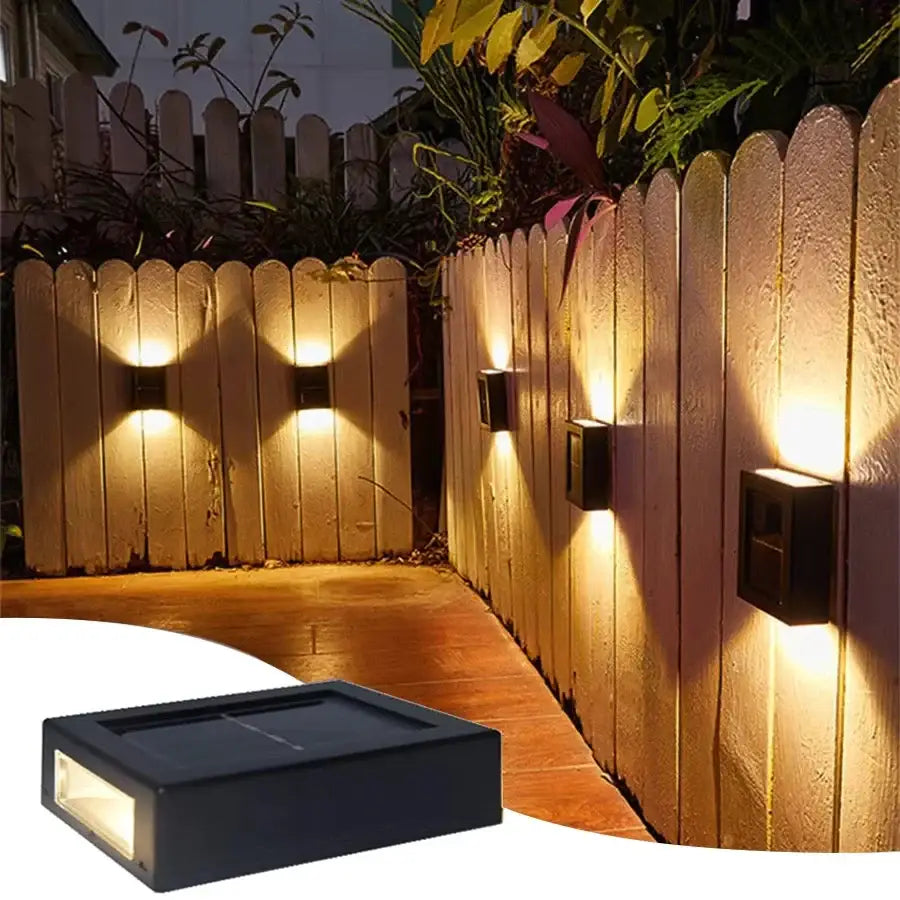 Black Solar Wall Light Decorbites outdoor lighting on a fence with warm glow from multiple units on Tampa Home & Garden Store