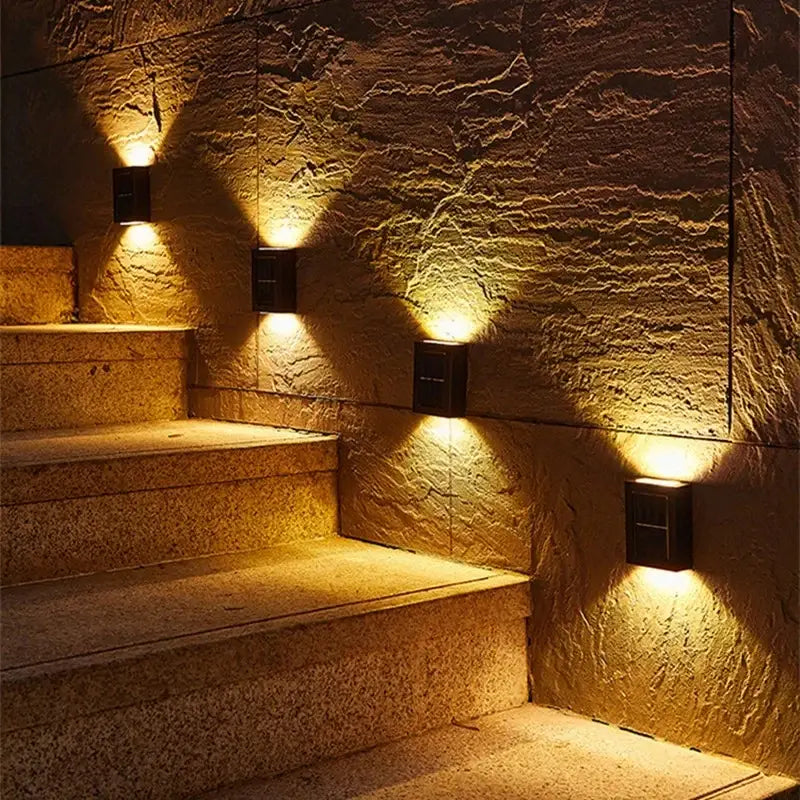 Black solar wall light Decorbites 5 black metal wall sconces along stairs casting warm uplight on Tampa Home & Garden Store