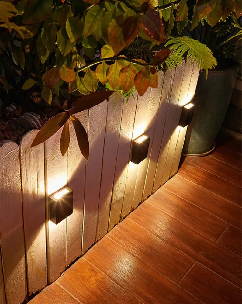 Black solar wall light cube by Decorbites; 4 outdoor cube lights along a planter with warm glow on Tampa Home & Garden Store