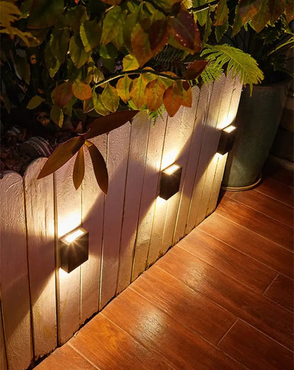 Black solar wall light cube by Decorbites; 4 outdoor cube lights along a planter with warm glow on Tampa Home & Garden Store