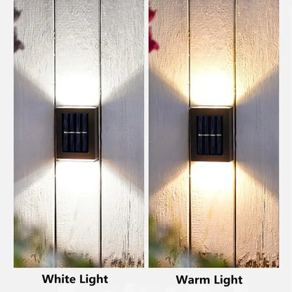 Black Solar Wall Light by Decorbites mounted on white fence, displaying white and warm light on Tampa Home & Garden Store