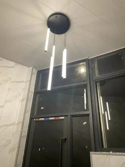 Modern black pendant chandelier with three cylindrical LED rods from a round ceiling mount on Tampa Home & Garden Store