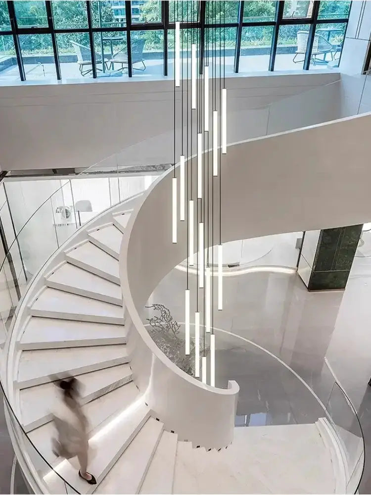 Decorbites modern black spiral LED chandelier with vertical tubes above a spiral staircase on Tampa Home & Garden Store