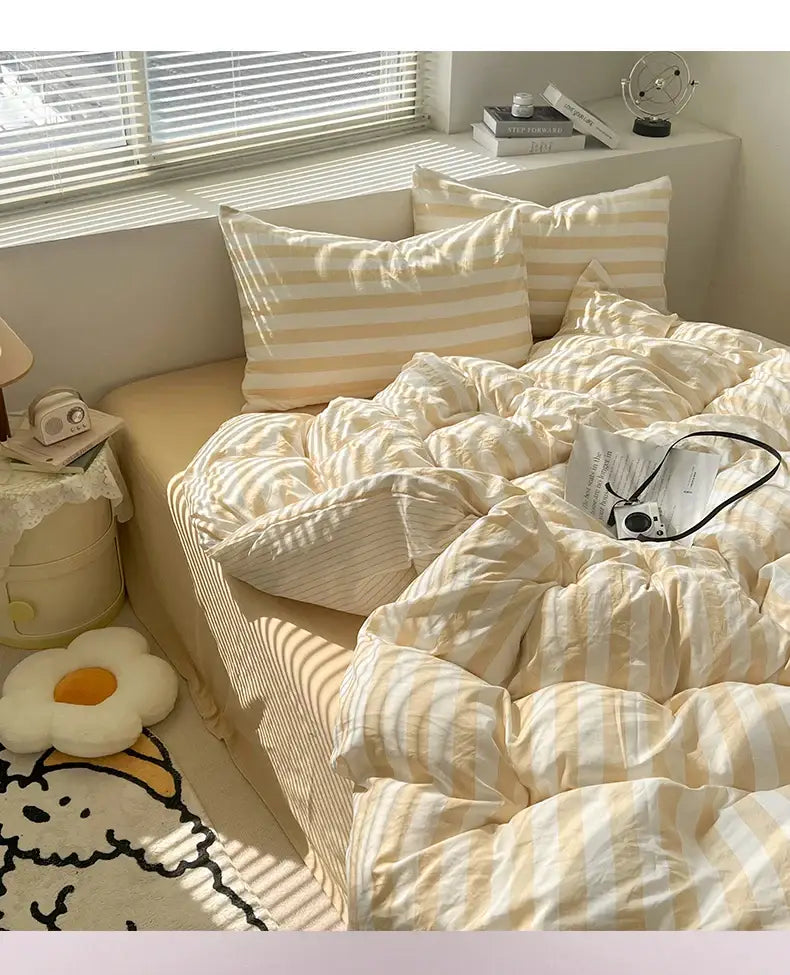 Cream striped quilted duvet cover by Decorbites with beige stripes on a bed with pillows on Tampa Home & Garden Store