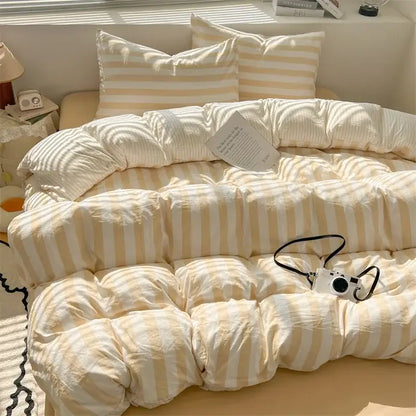 Cream striped quilted quilt on bed with matching striped pillow shams, ivory beige tones on Tampa Home & Garden Store