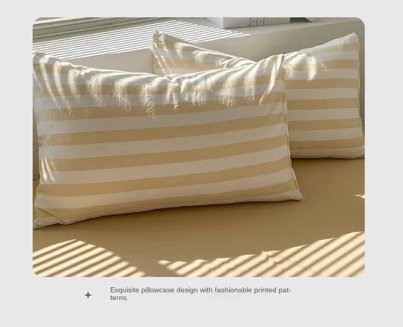 Cream Striped Quilted Quilt by Decorbites, two beige ivory striped pillows on a sunlit bed on Tampa Home & Garden Store