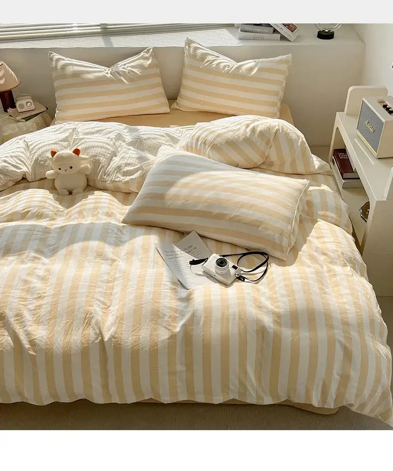 Decorbites cream striped quilted duvet cover set on bed with matching striped pillows on Tampa Home & Garden Store