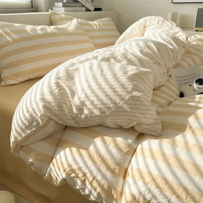 Cream striped quilt by Decorbites on a bed with matching striped pillows on Tampa Home & Garden Store