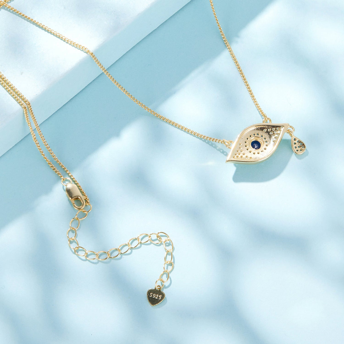 Gold-tone eye pendant necklace with blue center CZ and pavé accents; includes S925 heart charm on Tampa Home & Garden Store