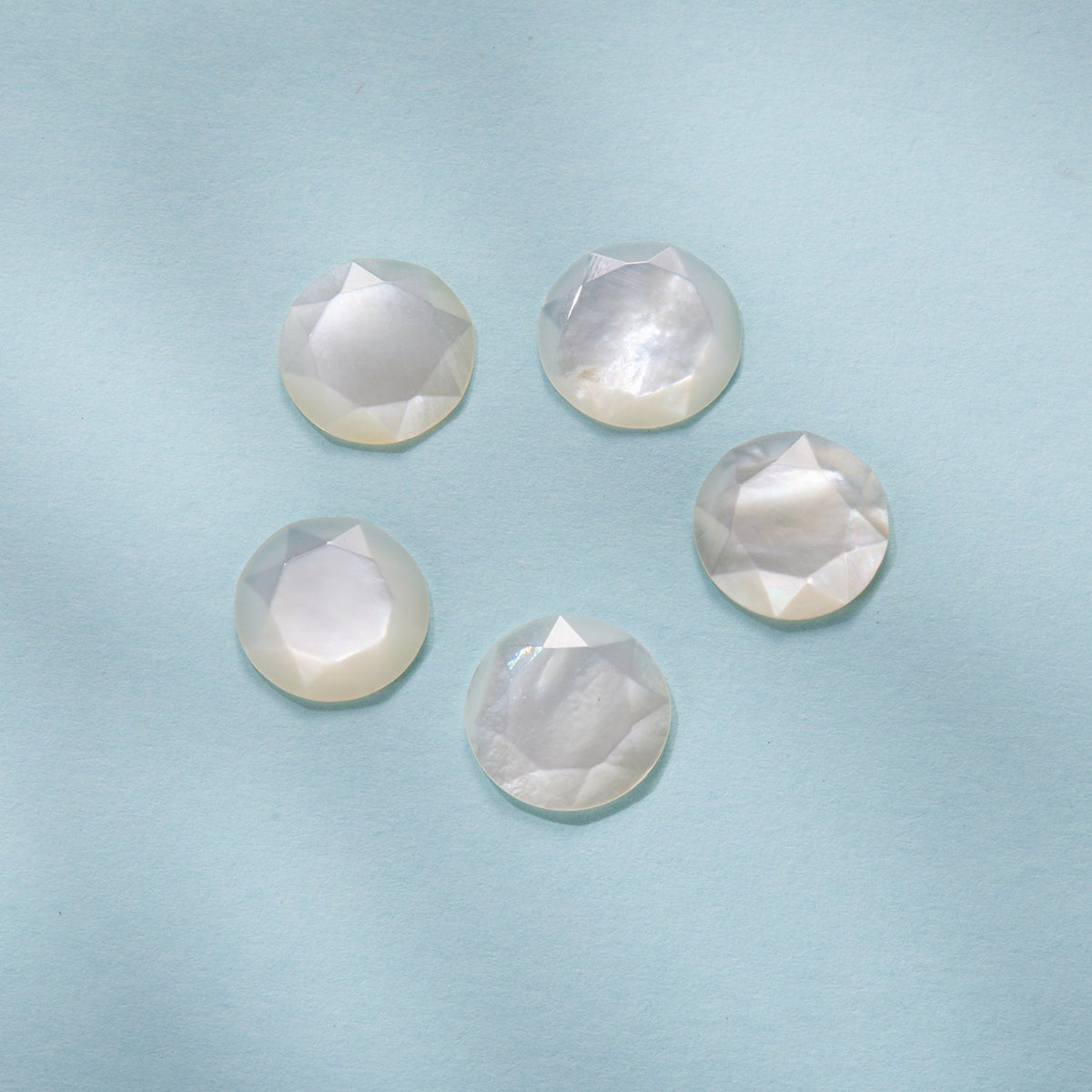 Six round faceted nacre stones with iridescent white sheen on Tampa Home & Garden Store