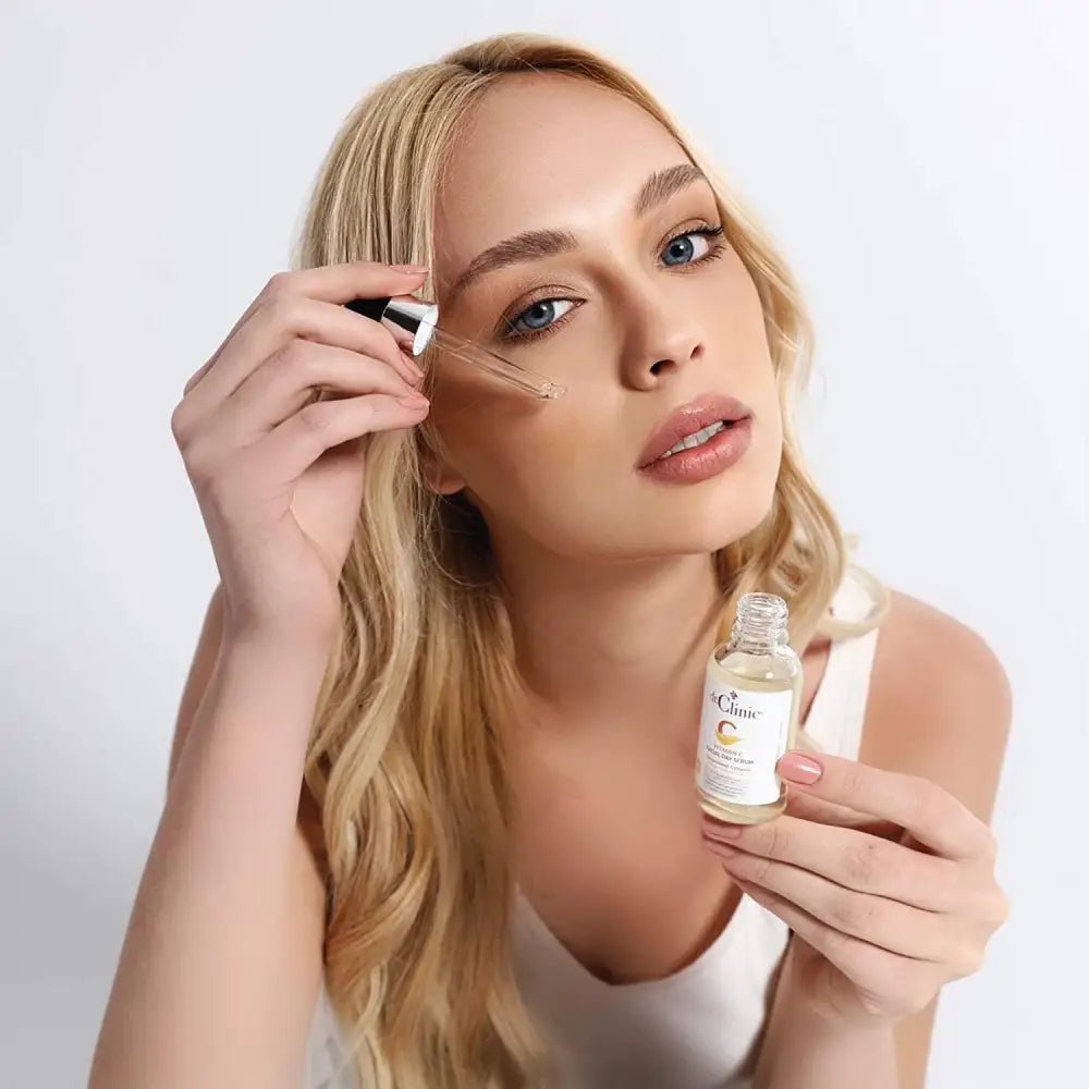 Dr.Clinic Vitamin C Facial Day Serum bottle with dropper held by a blonde user applying serum on her face on Tampa Home & Garden Store