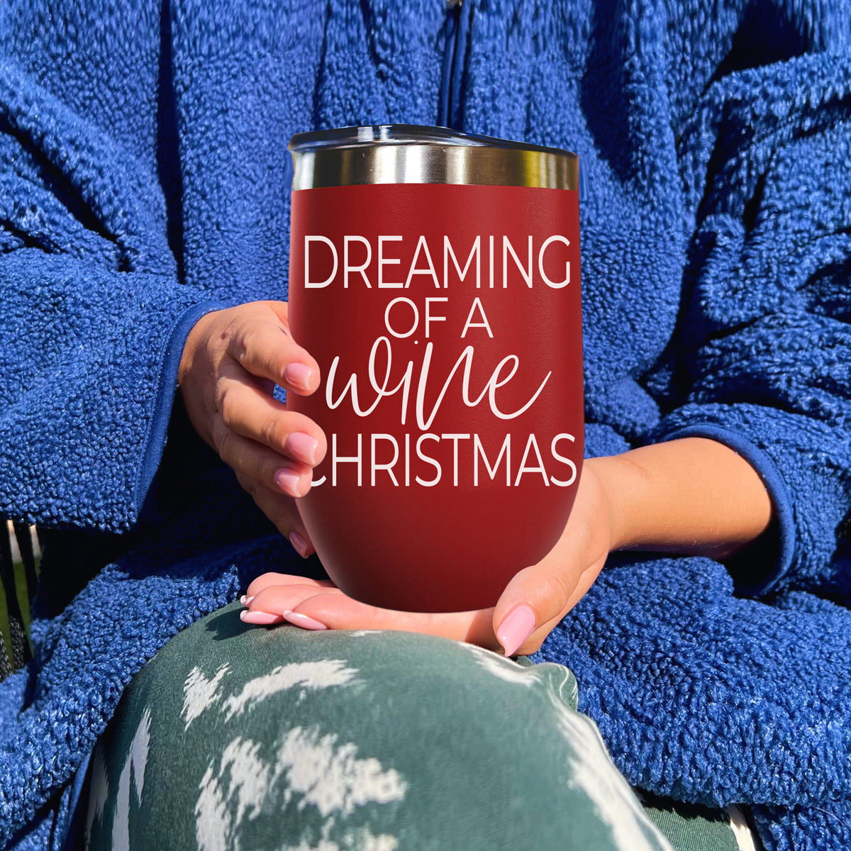 Gia Roma 17oz red tumbler with script Dreaming of a wine Christmas held by blue-robed hands on Tampa Home & Garden Store