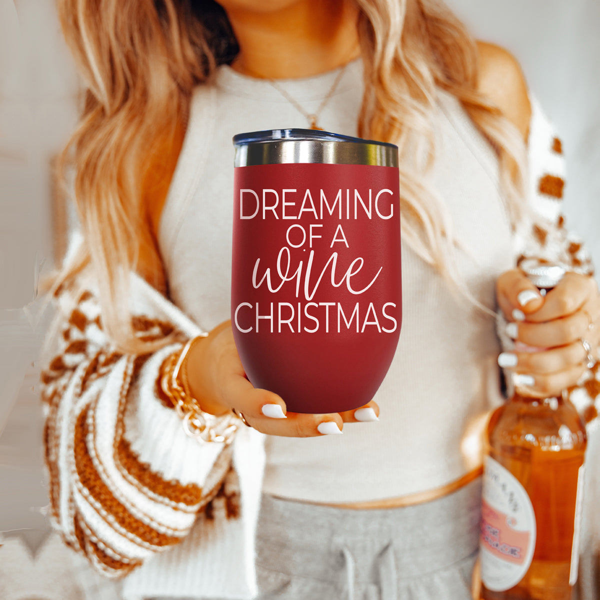 Gia Roma 17oz burgundy tumbler with white text Dreaming of a wine Christmas, held by person on Tampa Home & Garden Store