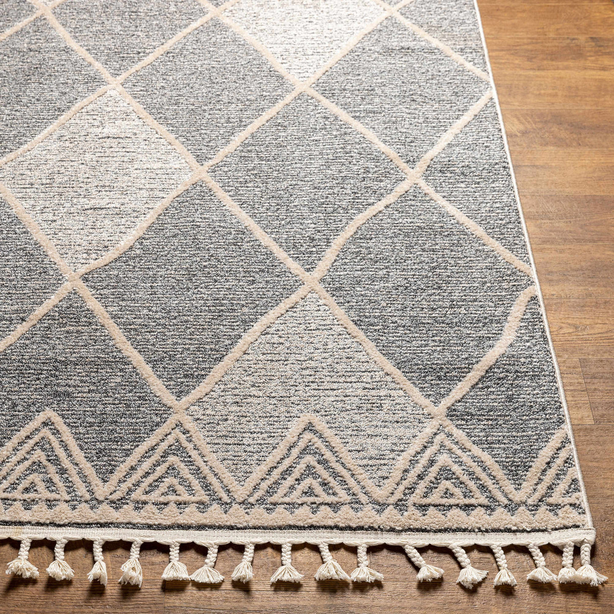 Dumlan Area Rug by Boutique Rugs gray beige lattice pattern with fringed border on wood floor on Tampa Home & Garden Store