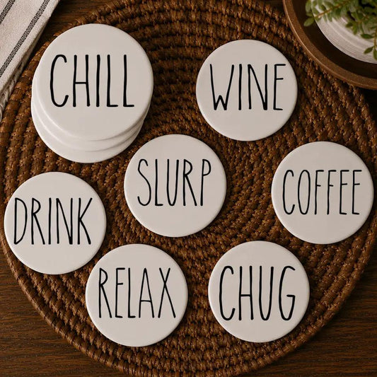 Coaster Gia Roma set of 7 one-word ceramic coasters in white with black lettering on a woven mat on Tampa Home & Garden Store