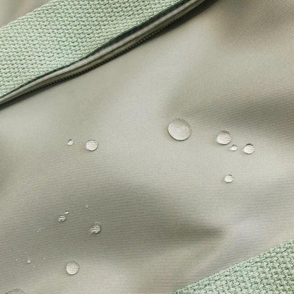 Laptop backpack fabric close-up in gray with water droplets and mint-green strap on Tampa Home & Garden Store
