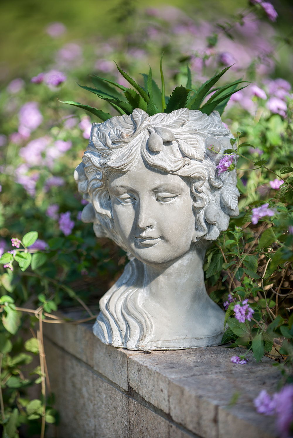 Cement bust wall planter gray with a green succulent on its head on Tampa Home & Garden Store