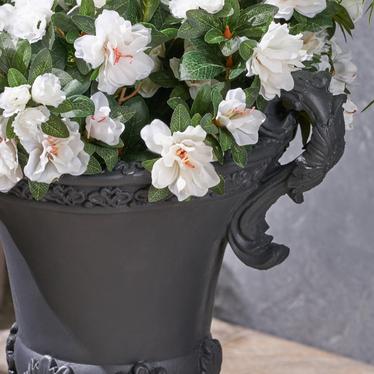 Delphine Urn Planter by HouseOfZazla with white blooms in an ornate black planter on Tampa Home & Garden Store