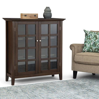 Acadian Medium Storage Cabinet in brown with glass doors; top features wooden box and vase on Tampa Home & Garden Store
