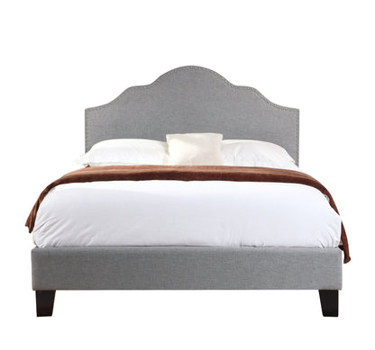 Kopa fabric upholstered bed headboard in grey with nailhead trim and dark wood legs on Tampa Home & Garden Store