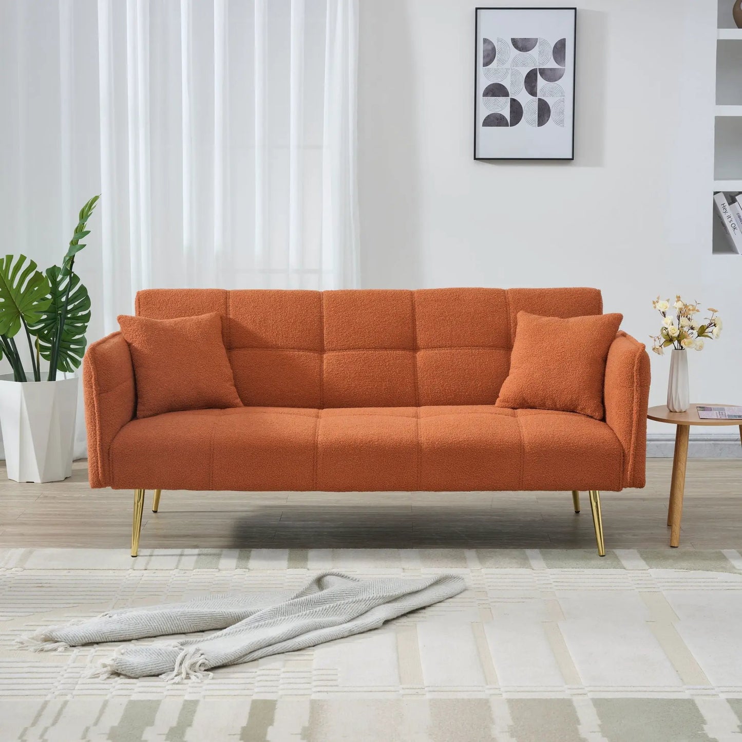 Convertible futon sofa bed in orange textured fabric with gold legs in a living room on Tampa Home & Garden Store