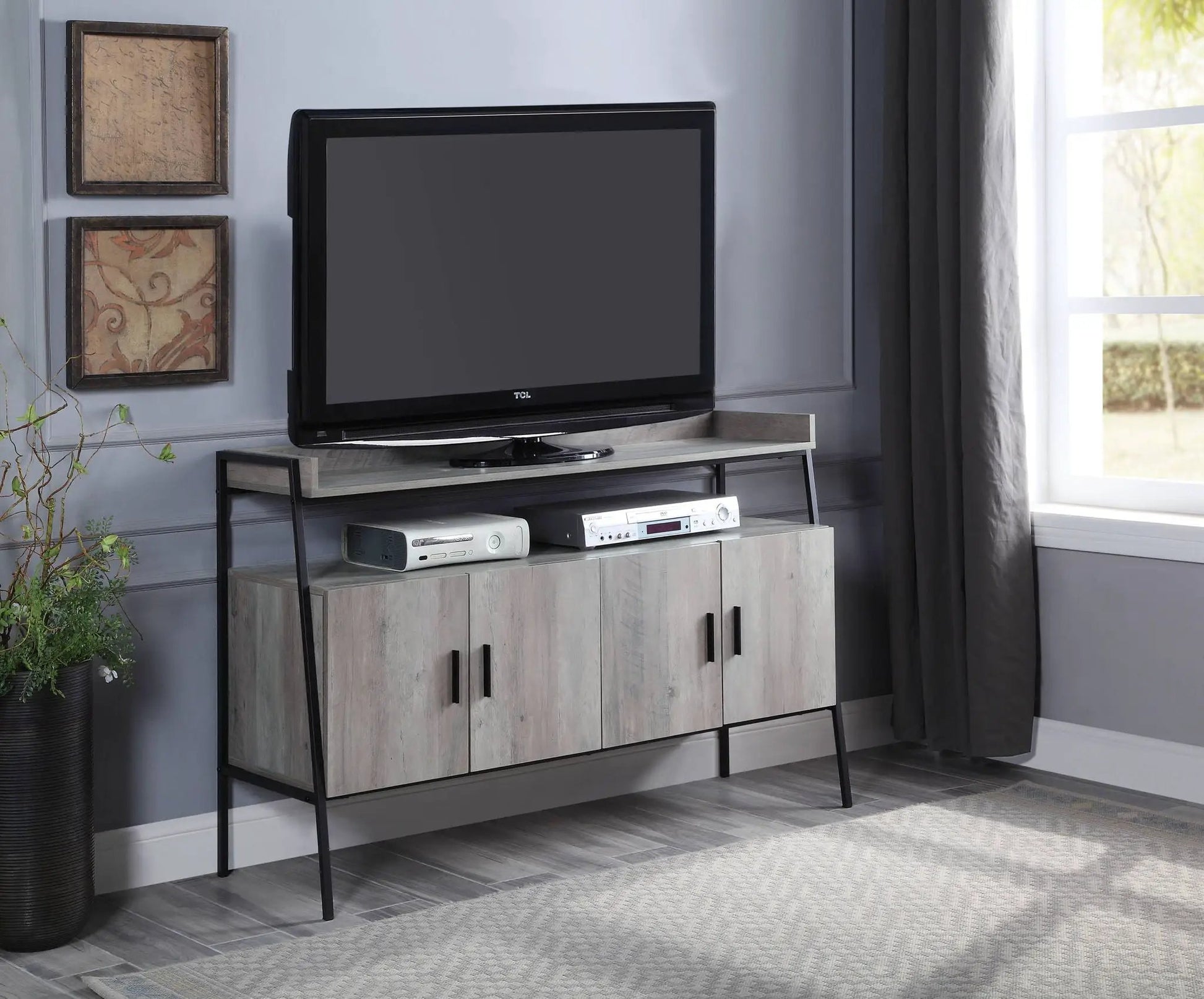 Samiya gray TV stand with gray wood doors and black metal legs, supports TCL TV on Tampa Home & Garden Store